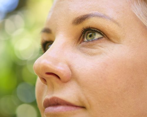 Close Up On Face Of Confident Mature Woman With Short Hair Standing Outdoors