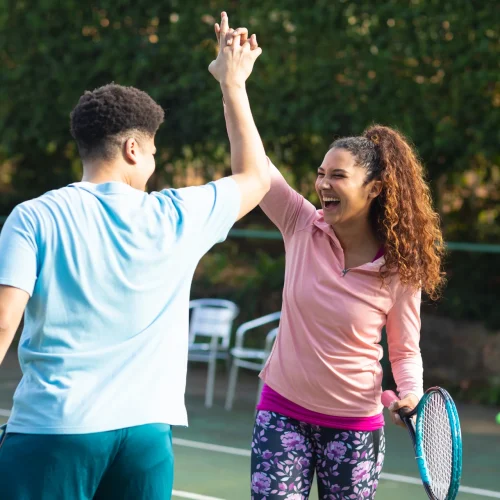 laughing-biracial-couple-playing-tennis-shaking-ha-2026-01-09-10-58-30-utc